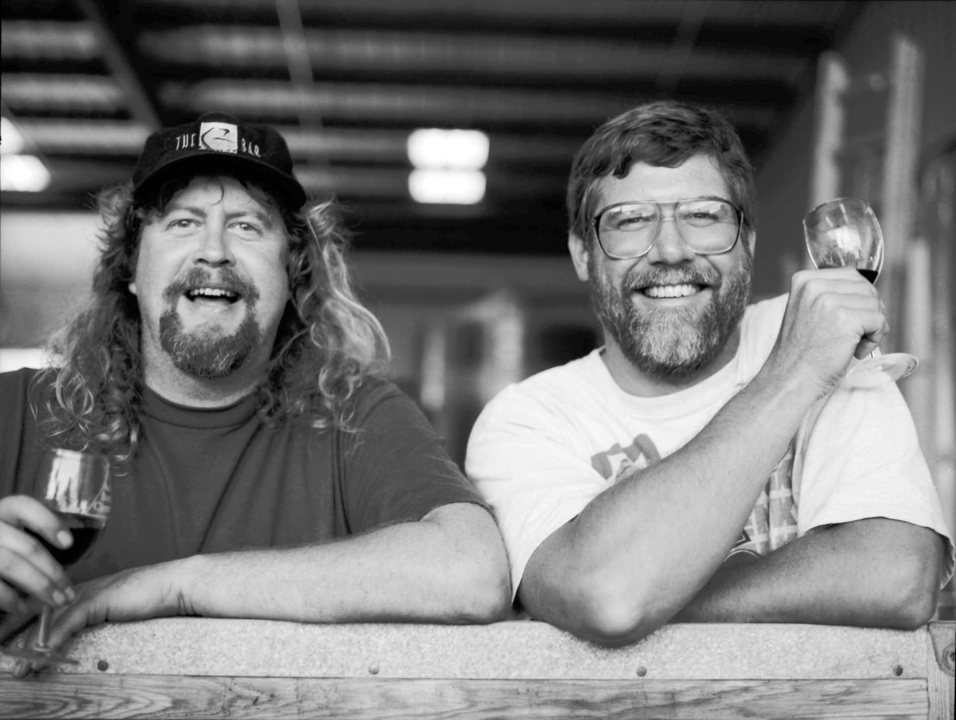 Bob Lindquist & Jim Clendenen leaning on barrels with wine in hand (black & white) (photo credit: Richard Tullis)